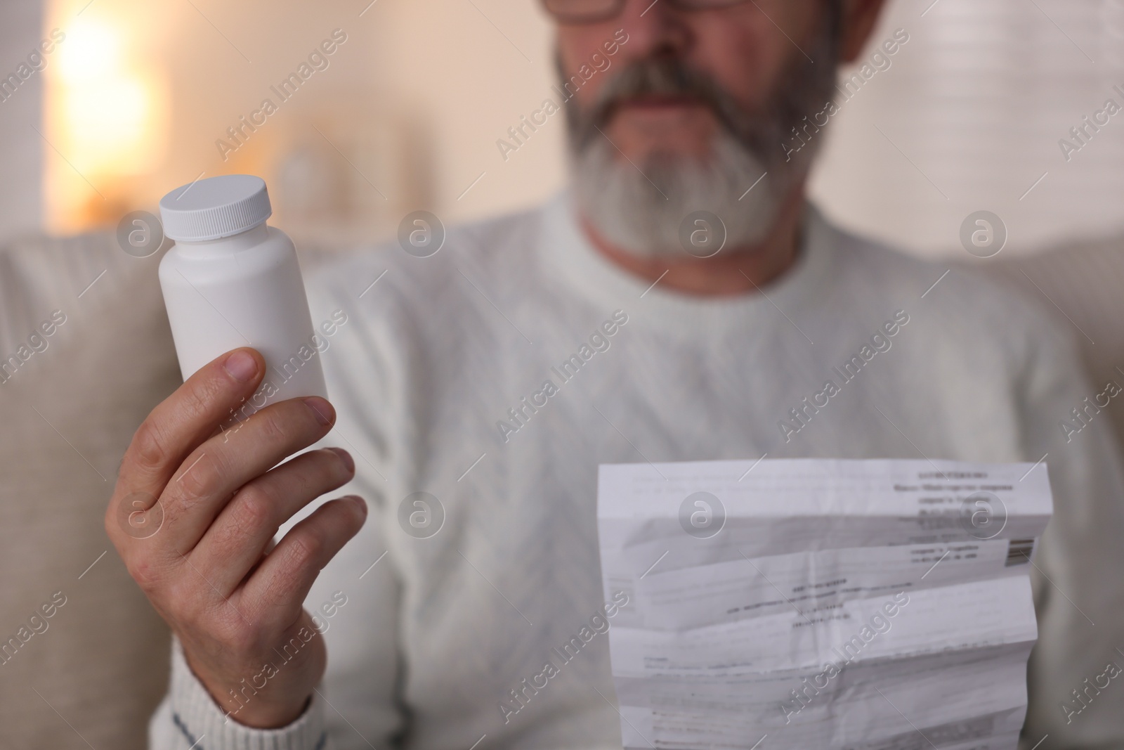 Photo of Senior man with bottle of pills and instruction at home, closeup