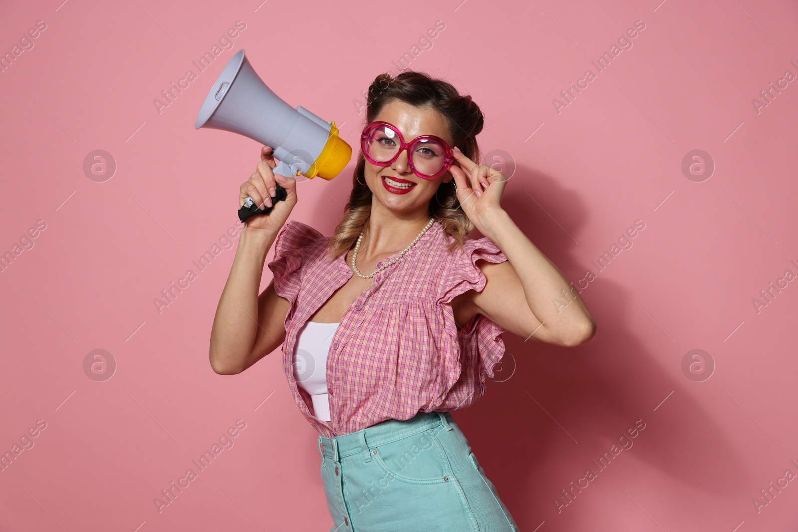 Photo of Happy pin-up woman with megaphone on pink background