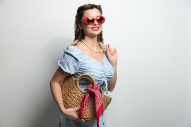 Photo of Happy pin-up woman in sunglasses on light background