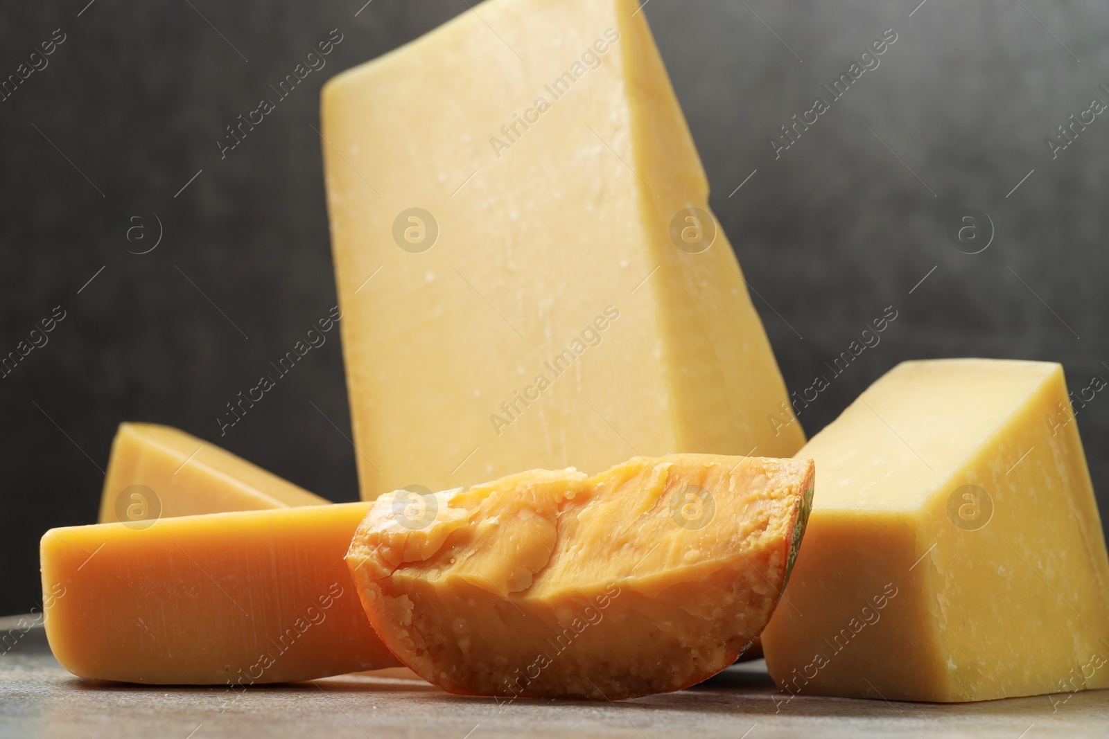 Photo of Different types of cheese on grey table, closeup