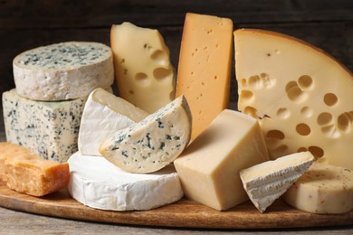 Photo of Different types of cheese on wooden table, closeup