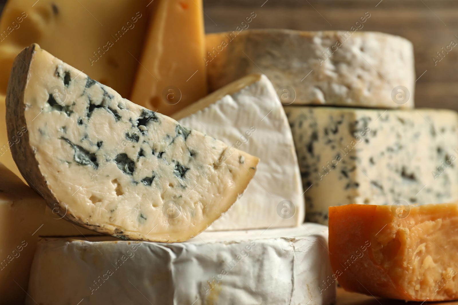 Photo of Different types of cheese on blurred background, closeup