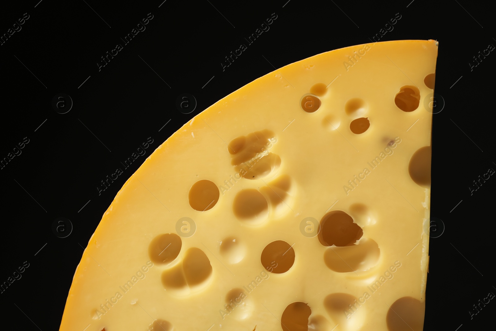 Photo of Piece of tasty cheese on black background, closeup