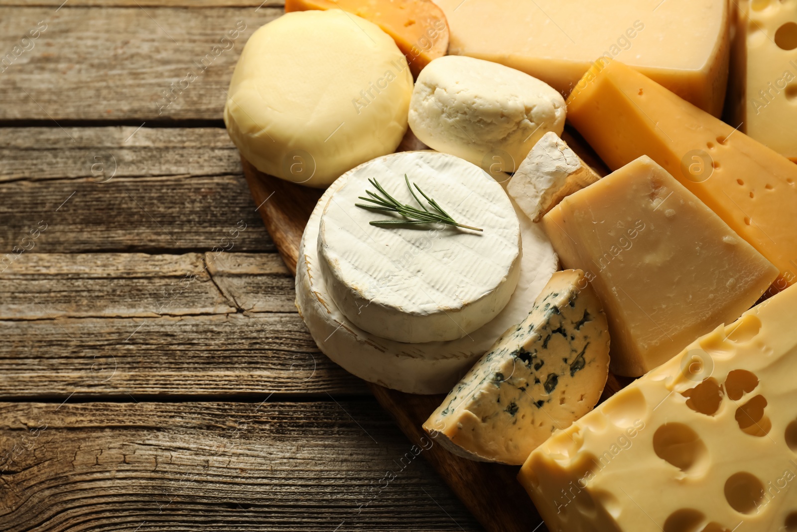 Photo of Different types of cheese on wooden table, closeup. Space for text