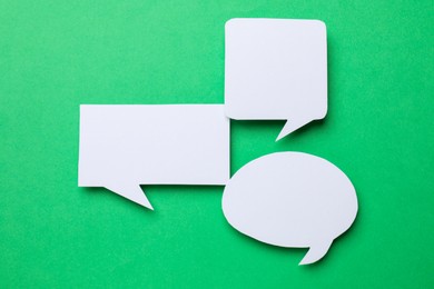 Photo of Blank speech bubbles on green background, top view. Space for text