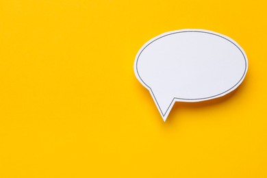 Photo of Blank speech bubble on yellow background, top view. Space for text