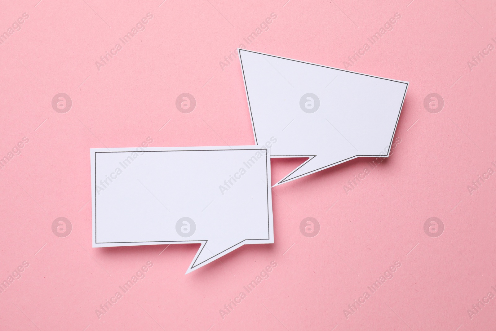 Photo of Blank speech bubbles on light pink background, top view. Space for text