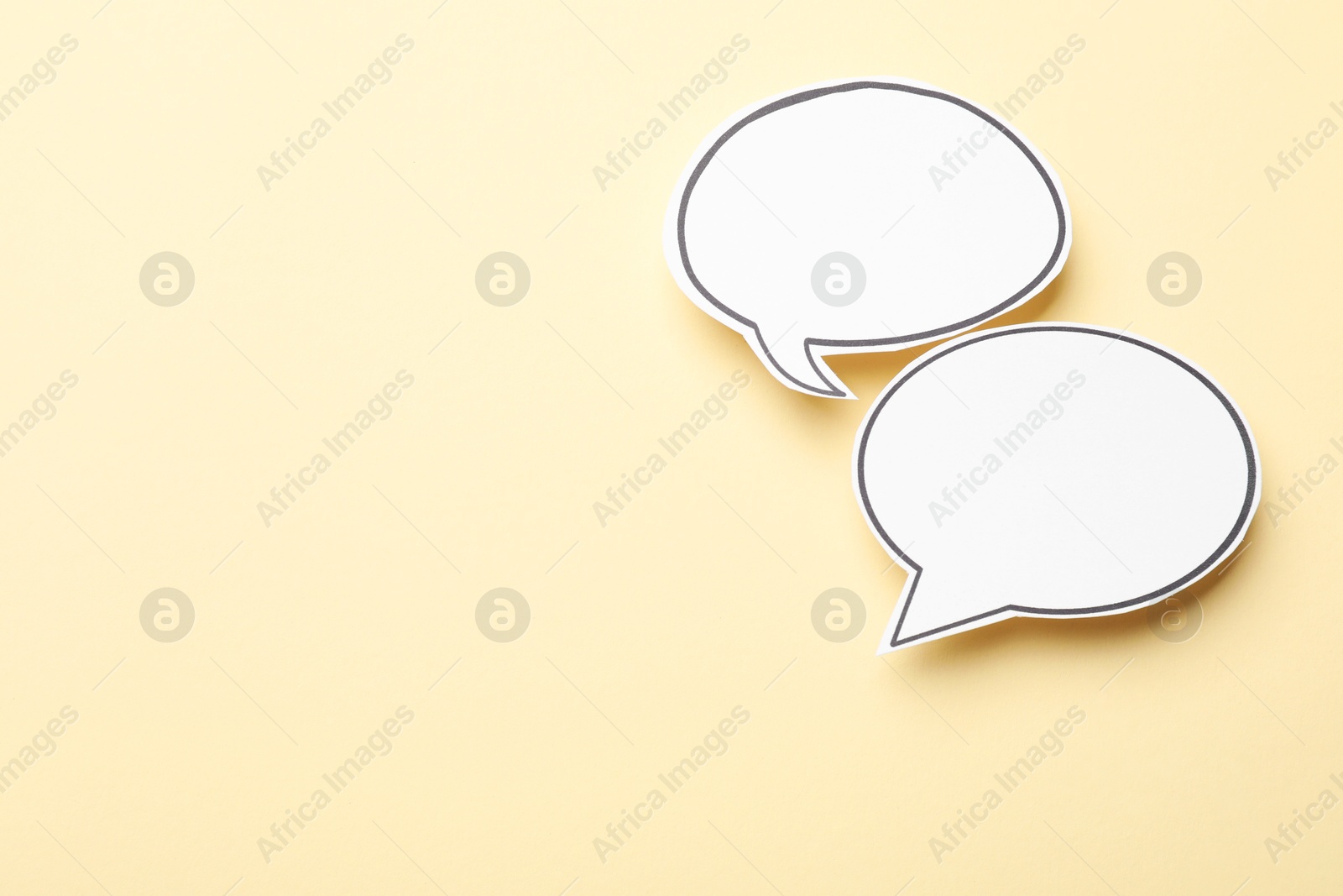 Photo of Blank speech bubbles on beige background, top view. Space for text