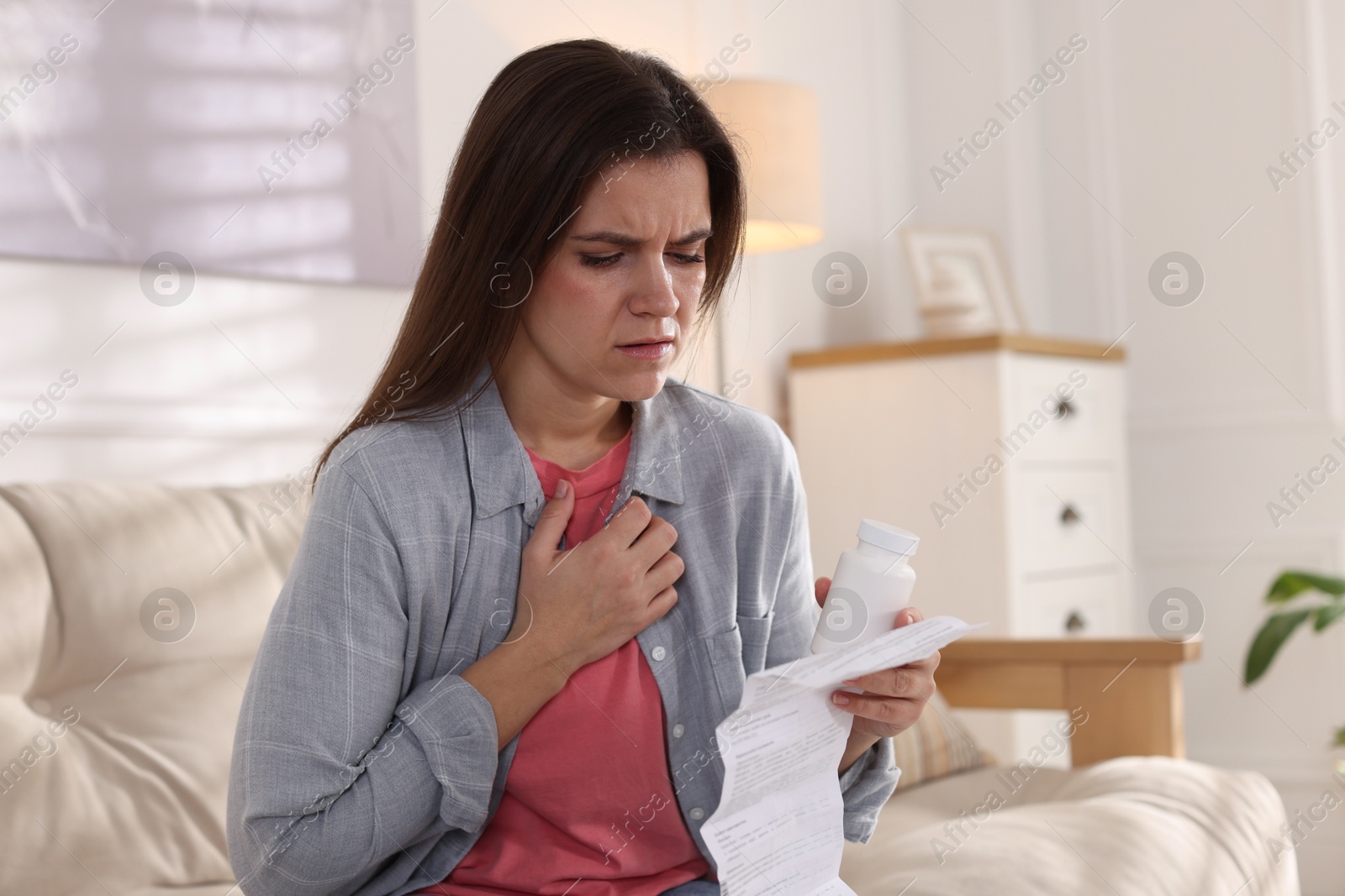 Photo of Woman with pills reading instruction at home, space for text