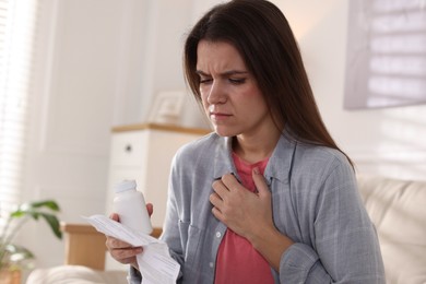 Photo of Woman with pills reading instruction at home