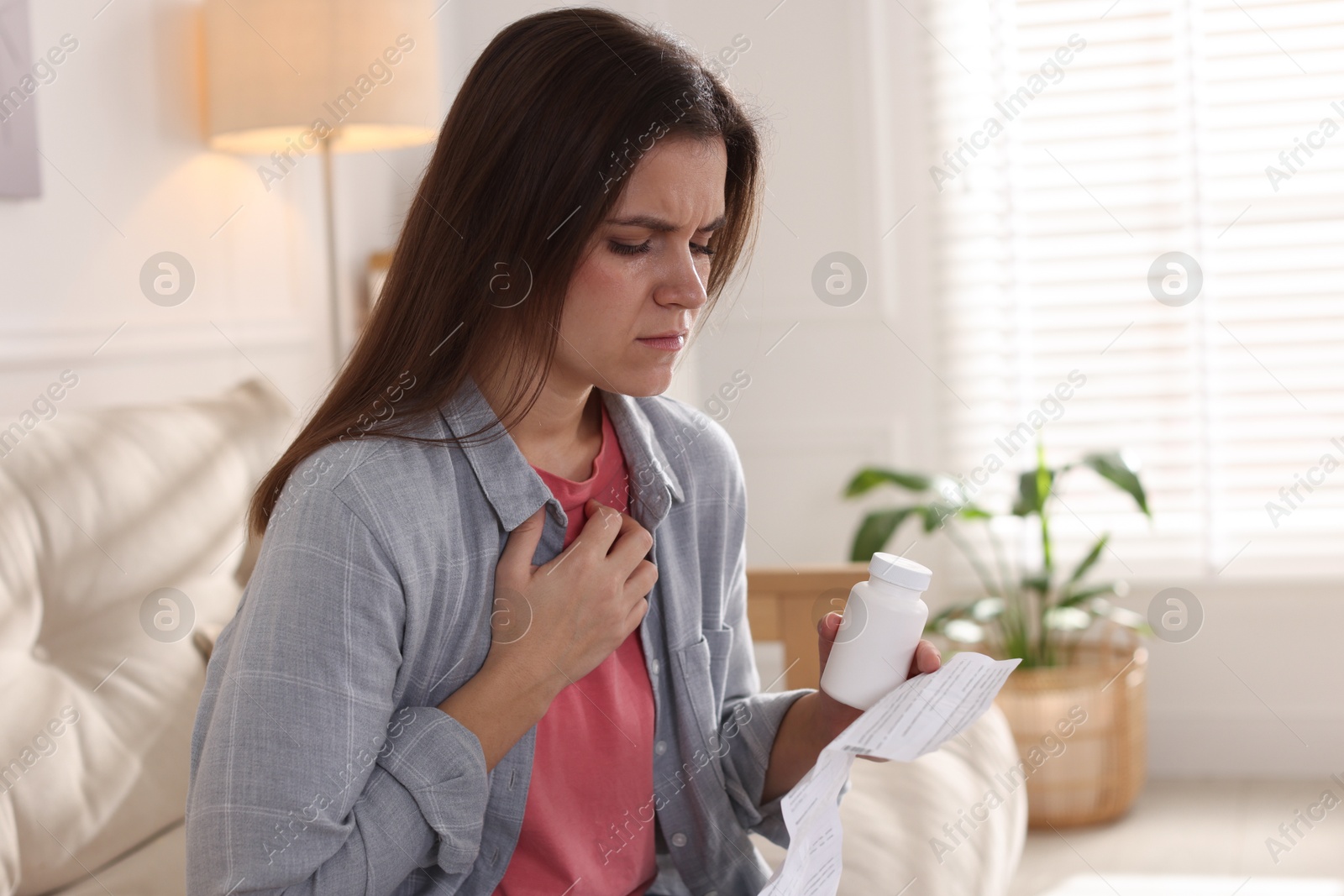 Photo of Woman with pills reading instruction at home, space for text