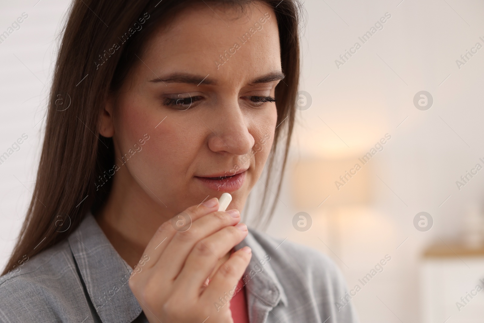 Photo of Woman taking medical pill at home, space for text