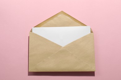 Kraft paper envelope with letter on pink background, top view. Mockup for design