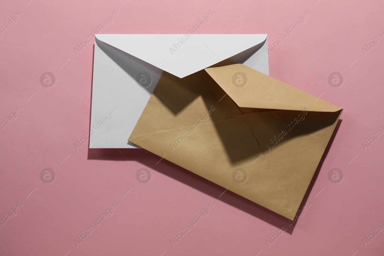 Photo of Paper envelopes on pink background, top view. Mockup for design