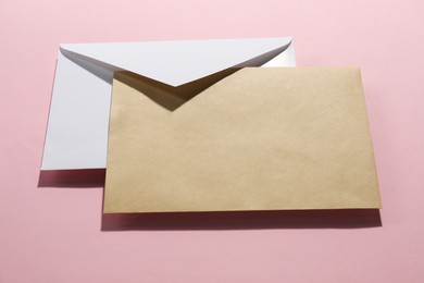 Paper envelopes on pink background, above view. Mockup for design