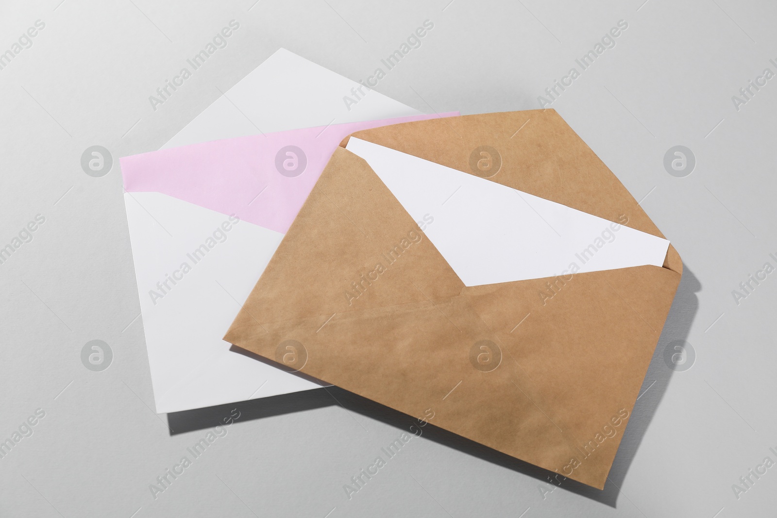 Photo of Paper envelopes with letters on grey background, above view. Mockup for design