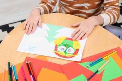 Photo of Girl making art project at table indoors, closeup