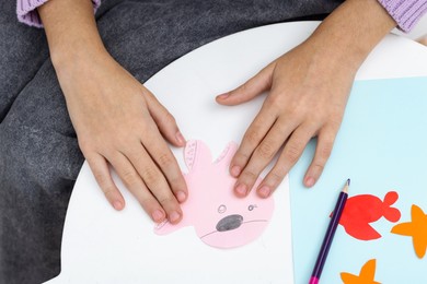 Photo of Girl making art project at table indoors, above view