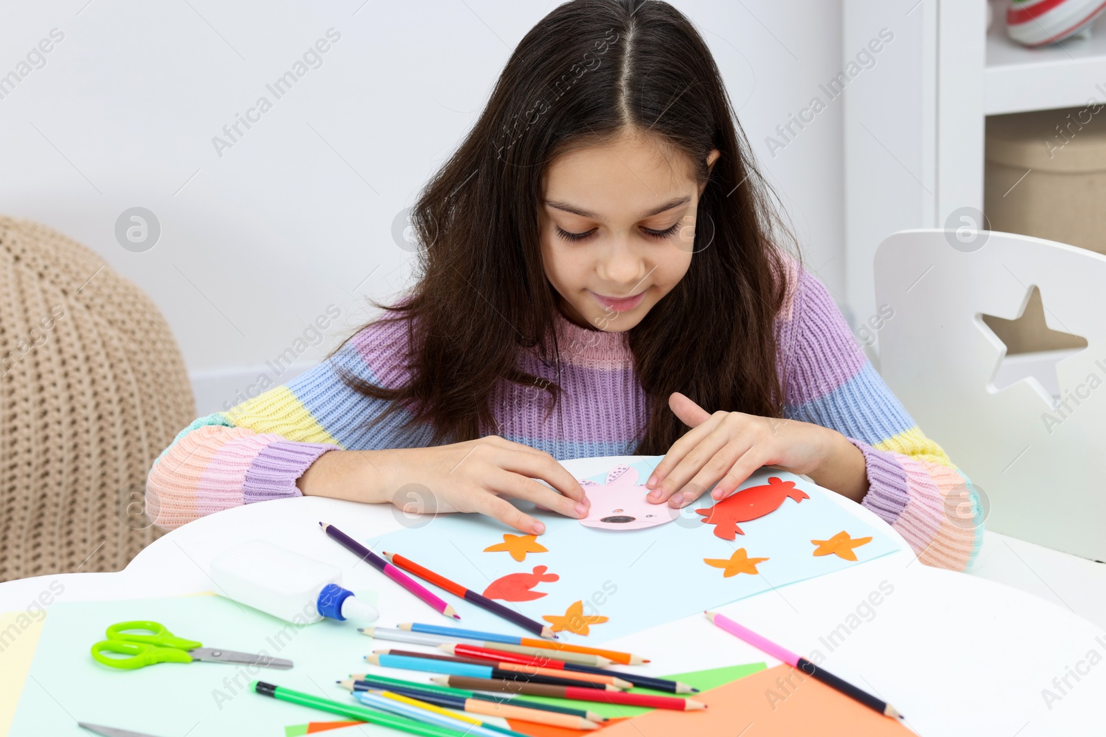 Photo of Girl making art project at table indoors