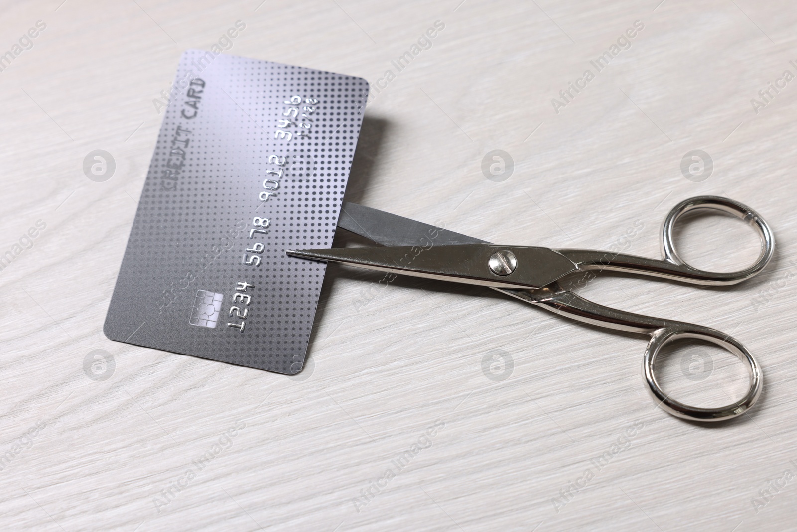 Photo of Credit card and scissors on white wooden table, above view