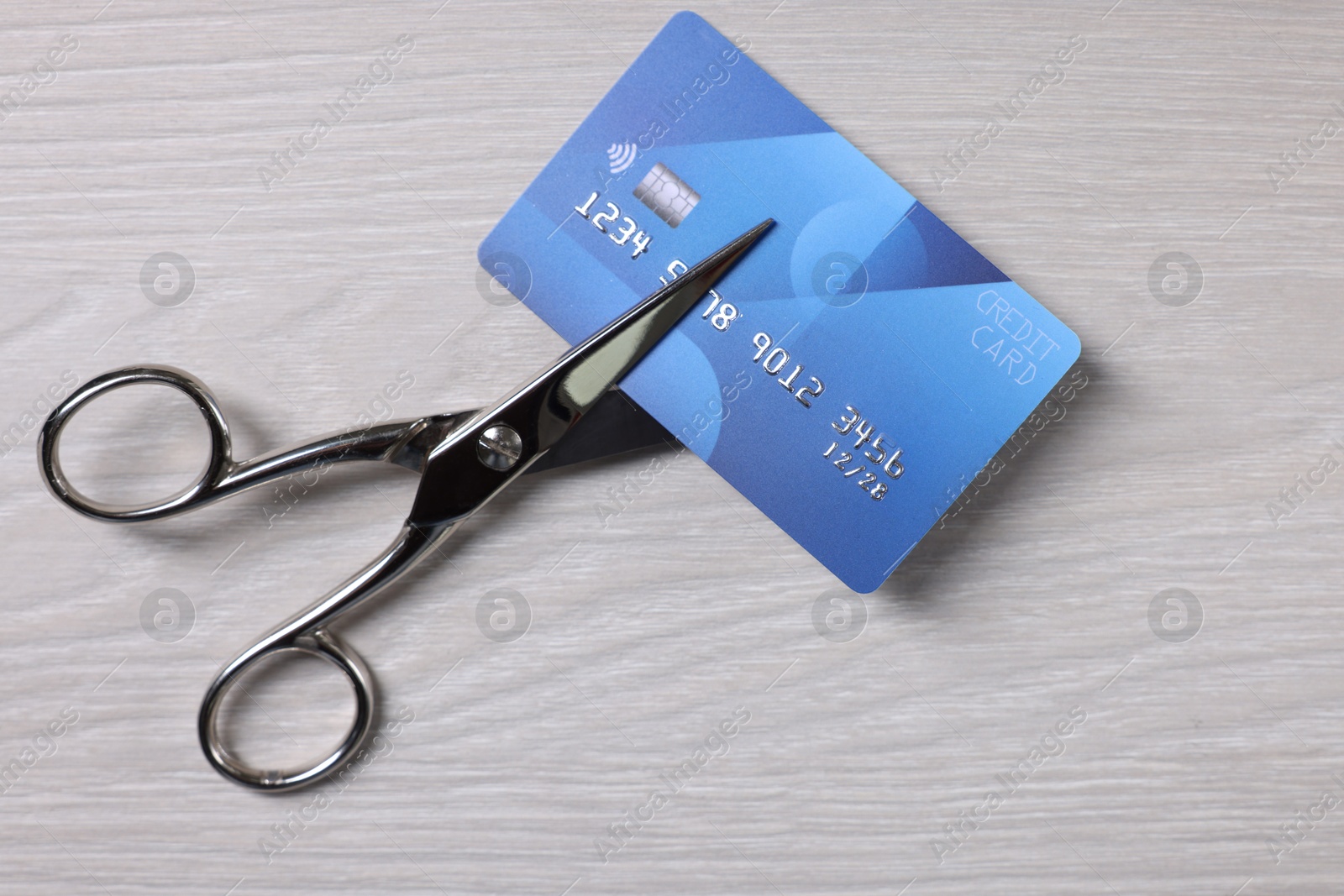 Photo of Credit card and scissors on white wooden table, top view