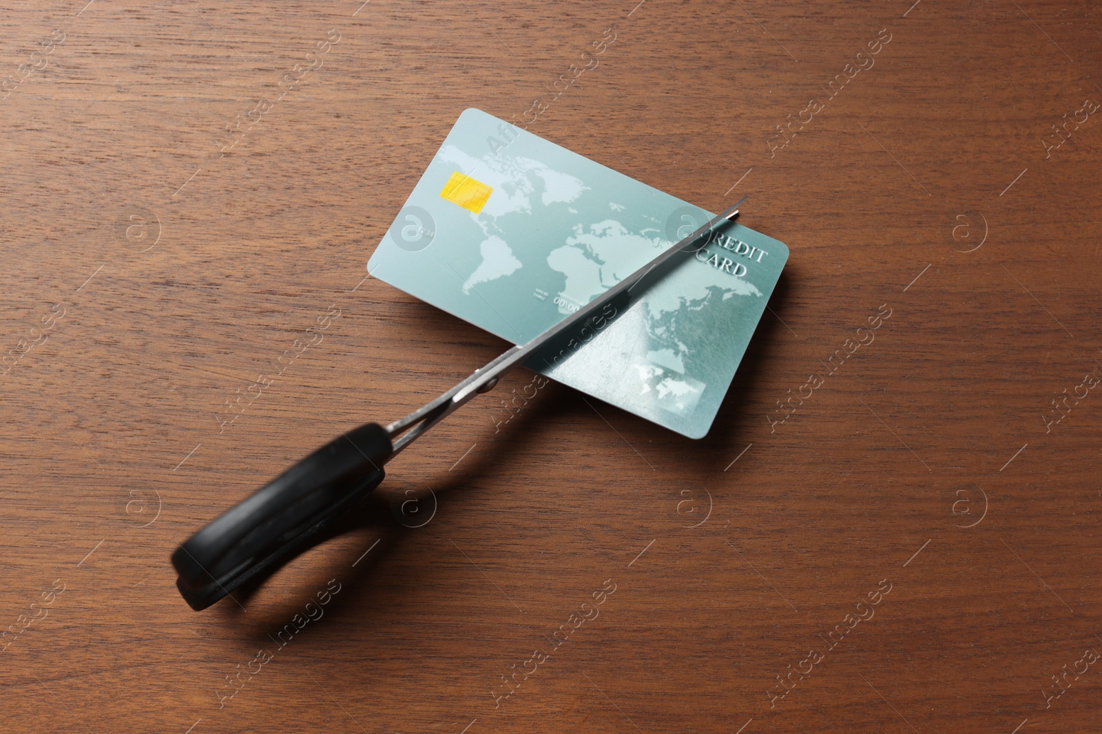 Photo of Credit card and scissors on wooden table, top view