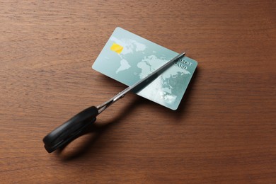 Photo of Credit card and scissors on wooden table, top view