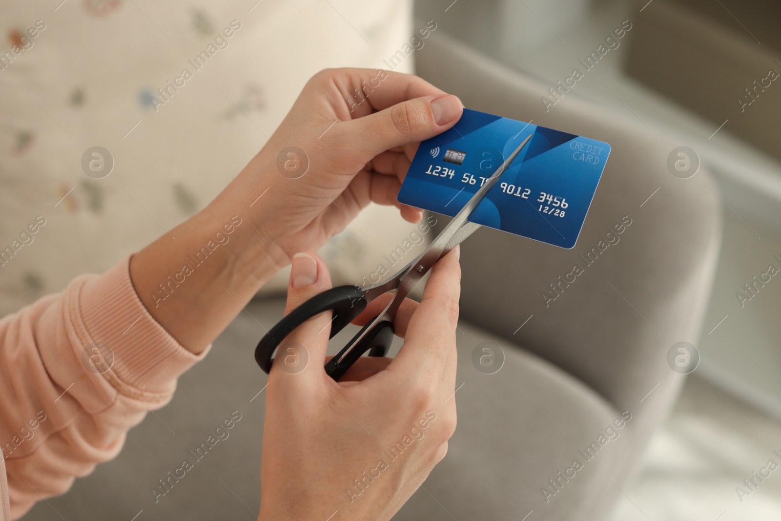 Photo of Woman cutting plastic credit card indoors, closeup