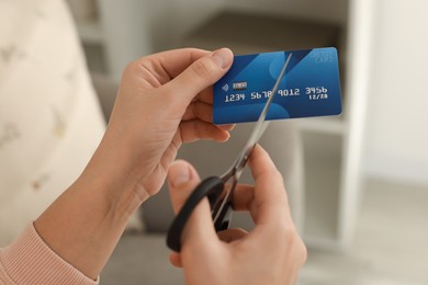 Photo of Woman cutting plastic credit card indoors, closeup