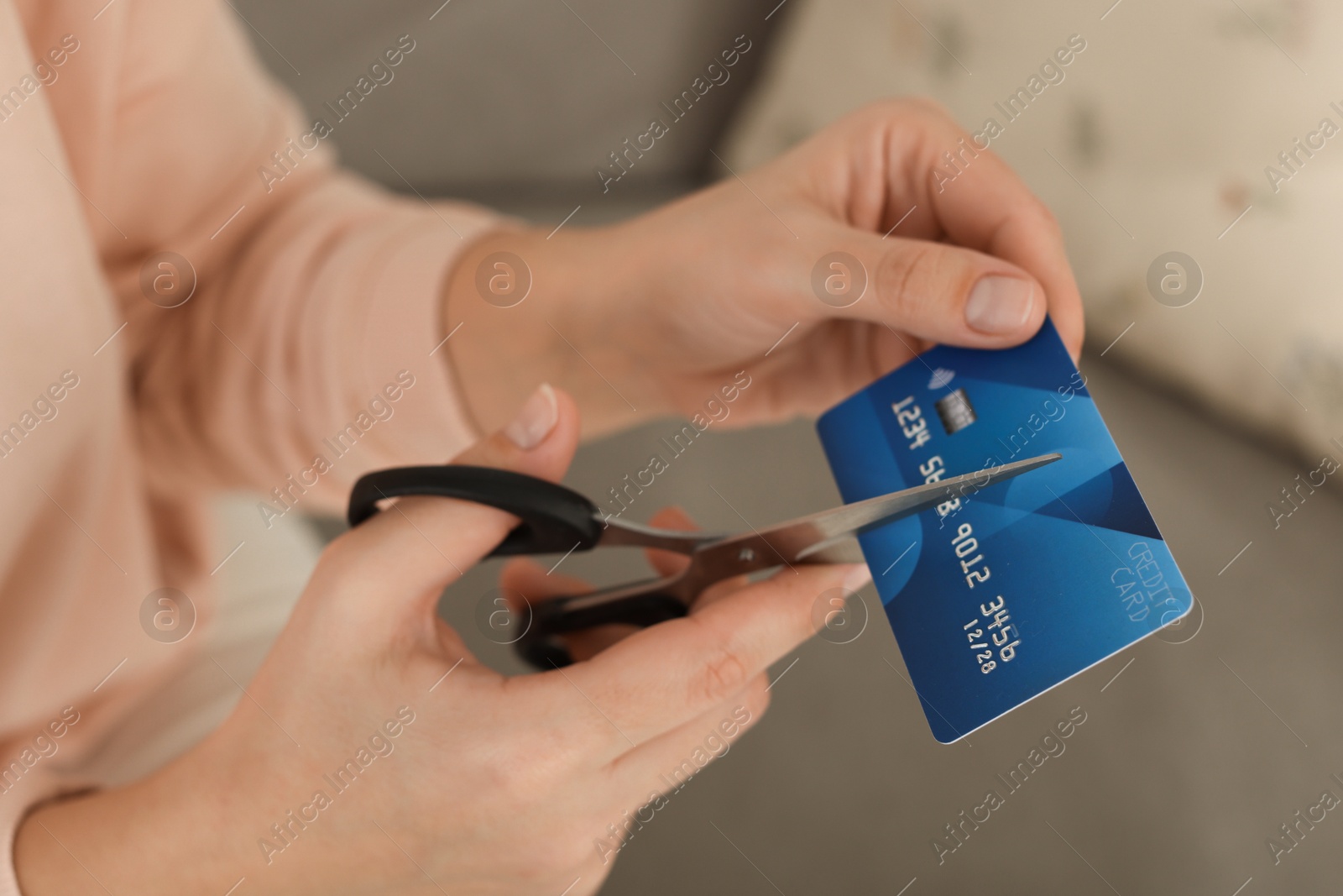 Photo of Woman cutting plastic credit card indoors, closeup