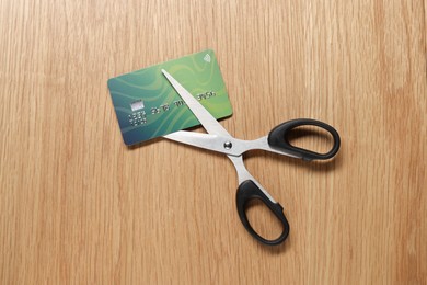 Photo of Credit card and scissors on wooden table, top view