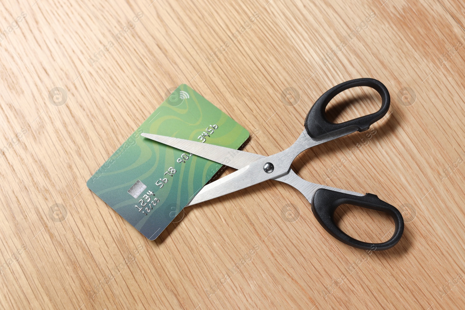 Photo of Credit card and scissors on wooden table, top view