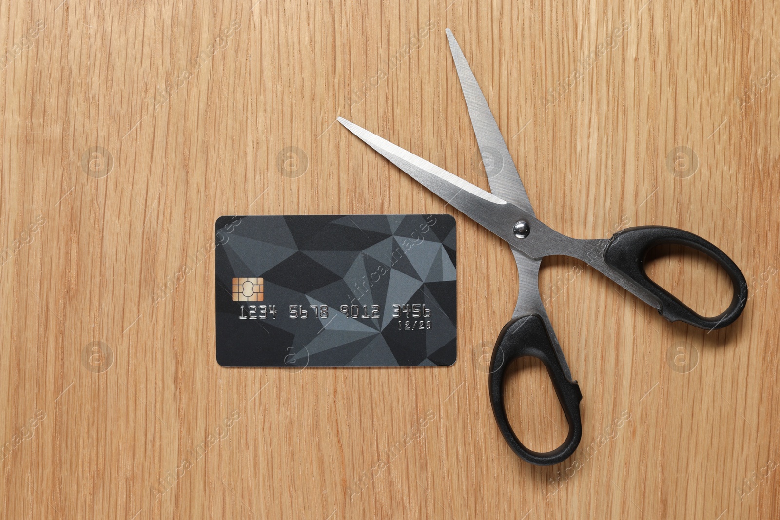 Photo of Credit card and scissors on wooden table, top view