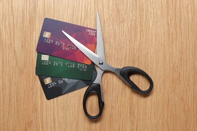 Photo of Credit cards and scissors on wooden table, top view