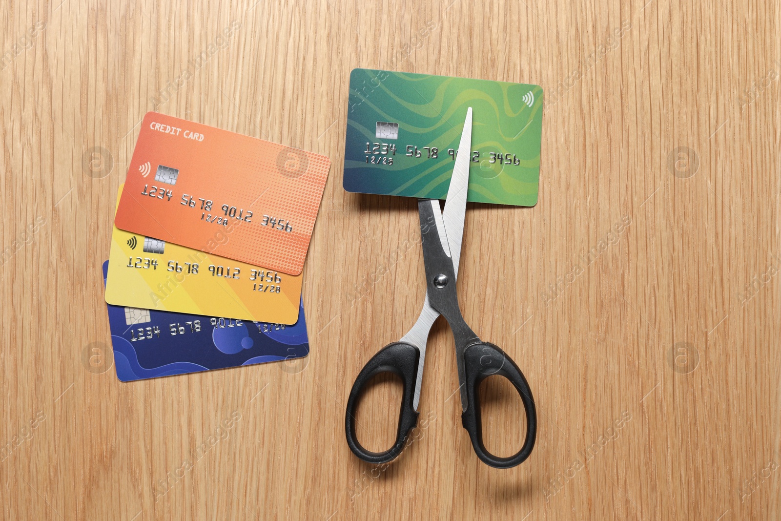 Photo of Credit cards and scissors on wooden table, top view