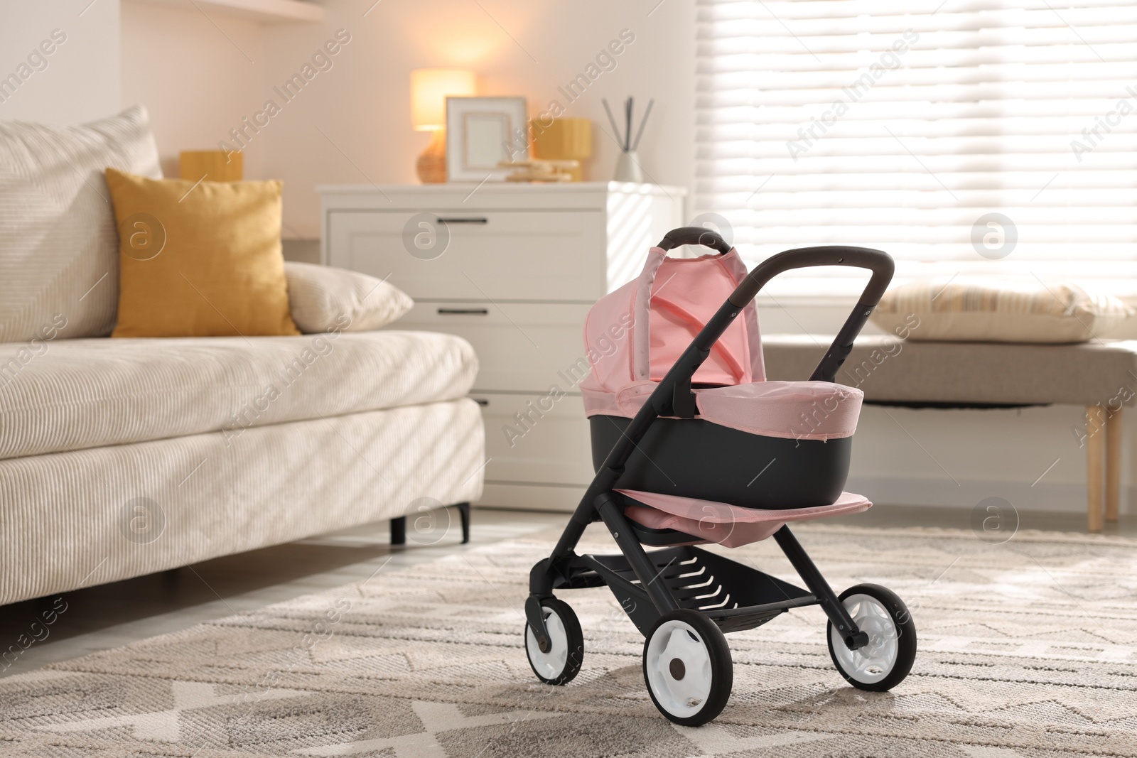 Photo of Doll stroller in living room. Kid's toy