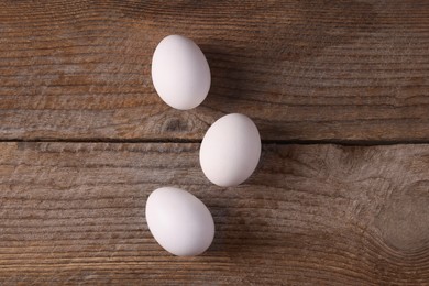 Photo of Group of fresh eggs on wooden table, flat lay