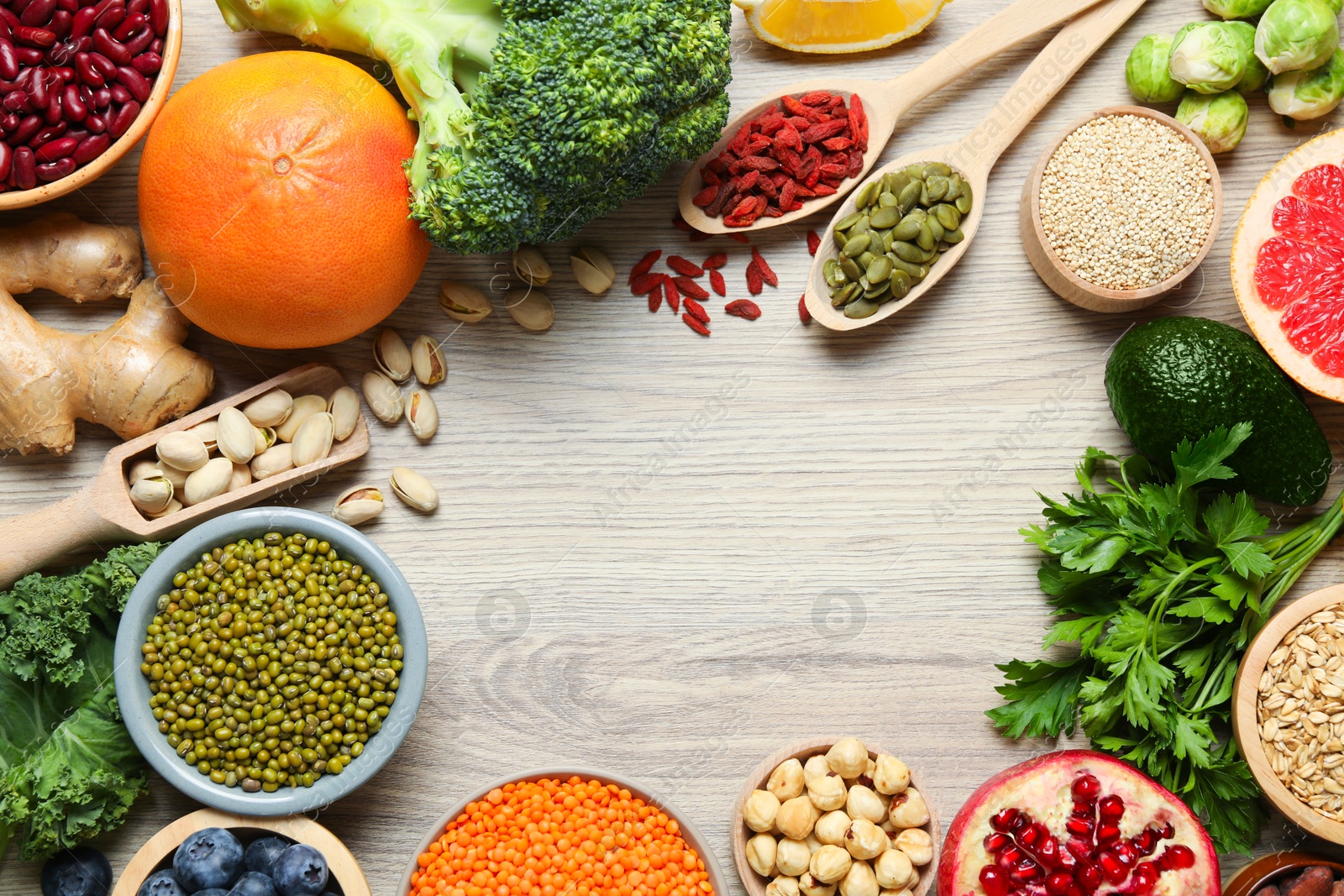 Photo of Frame of different superfood products on wooden table, flat lay. Space for text