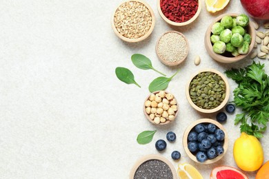 Photo of Different superfood products on light table, flat lay. Space for text