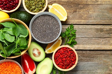 Photo of Different superfood products on wooden table, flat lay