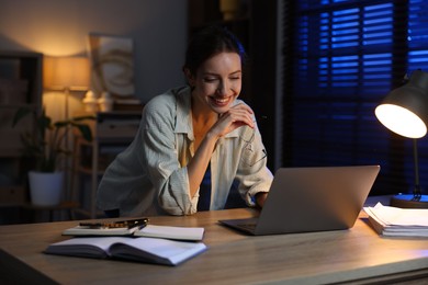 Photo of Woman working on laptop at desk in home office