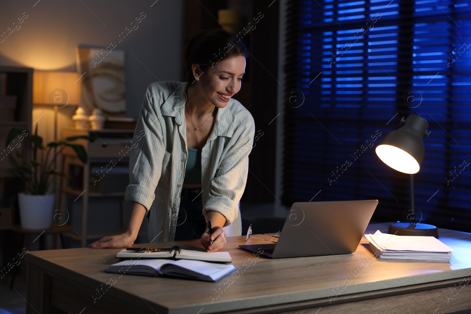 Photo of Woman working on laptop at desk in home office