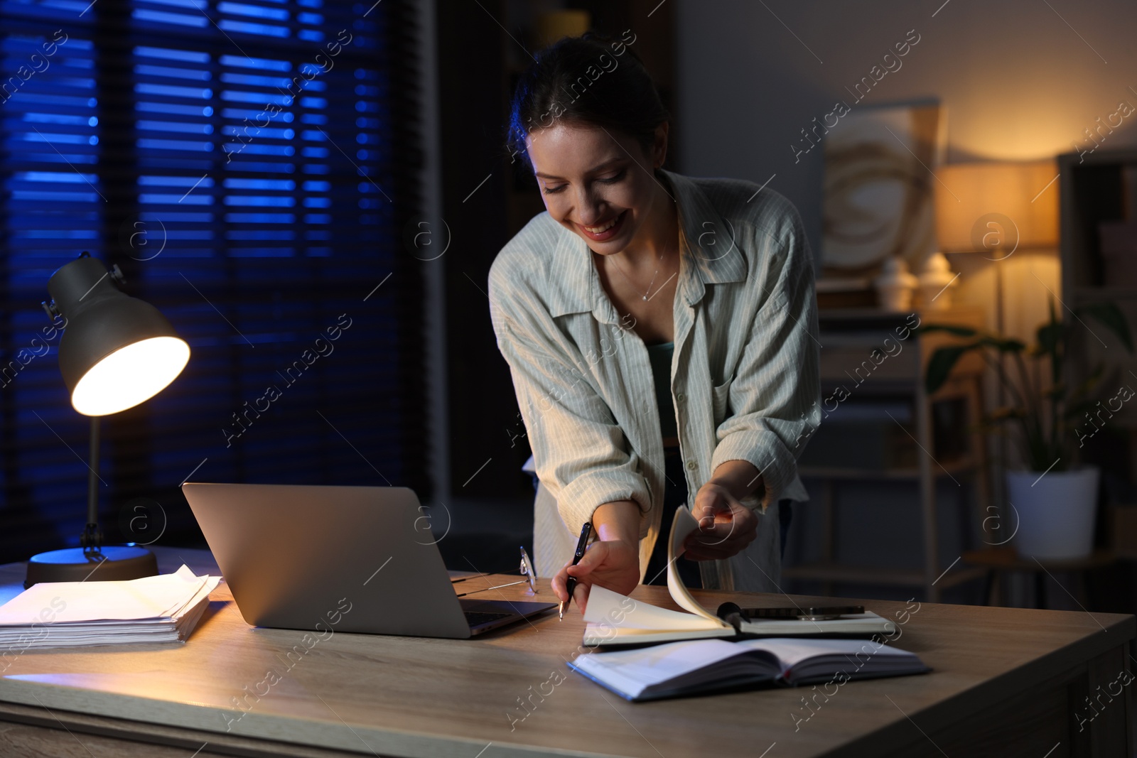 Photo of Woman working on laptop at desk in home office