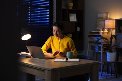 Photo of Woman working on laptop at desk in home office