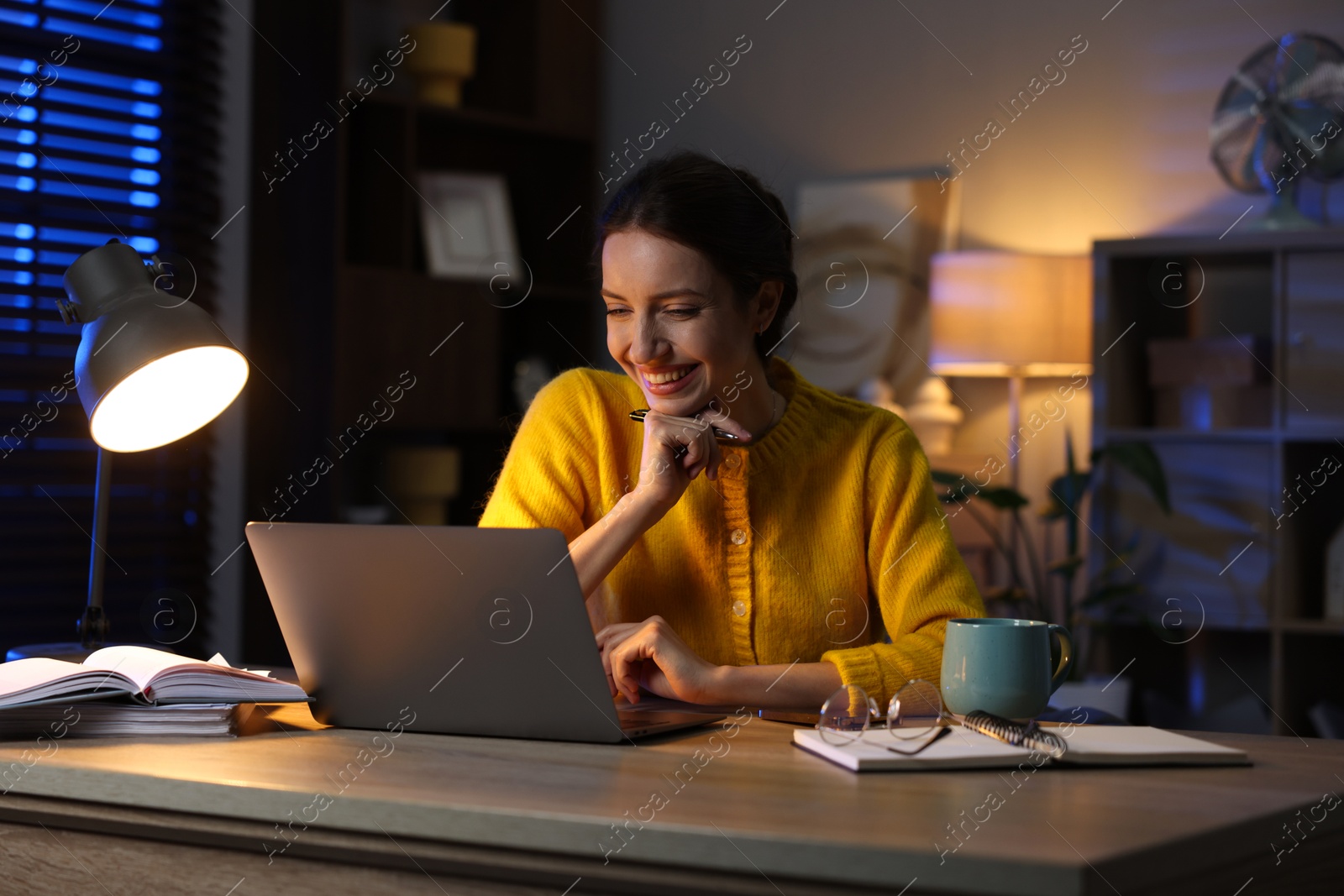 Photo of Woman working on laptop at desk in home office