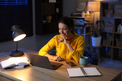 Photo of Woman working on laptop at desk in home office