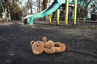 Photo of Lost brown teddy bear on ground outdoors