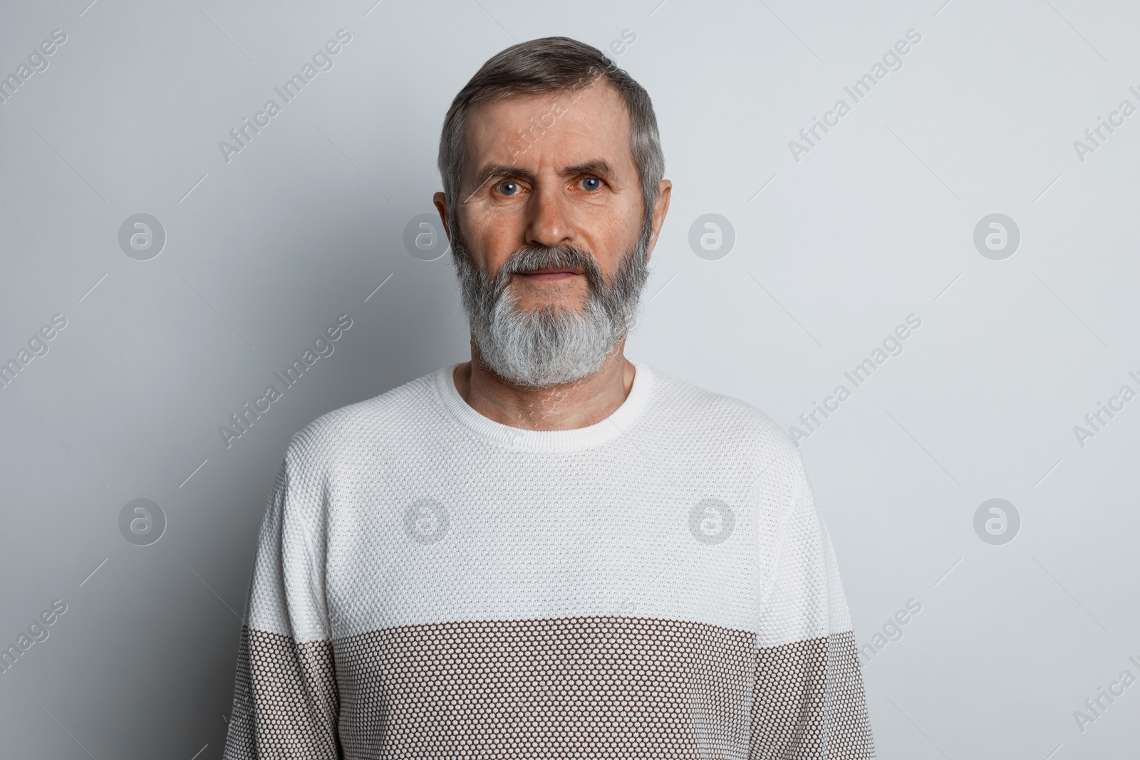 Photo of Portrait of mature man on light grey background