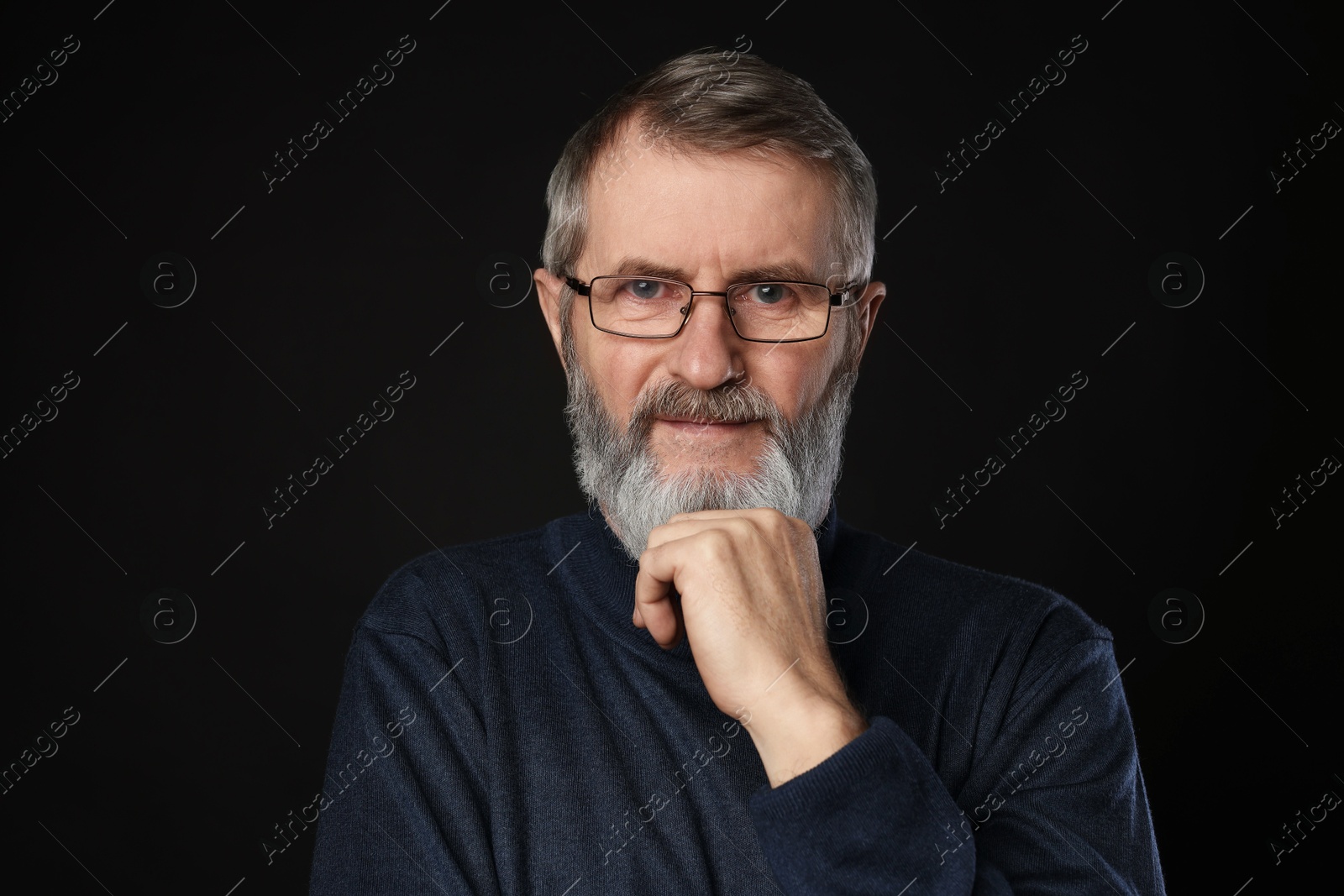 Photo of Portrait of mature man in glasses on black background