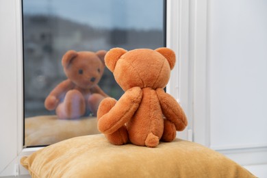 Photo of Teddy bear on window sill at home, back view